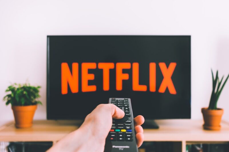 テレビのNetflix画面とリモコンを持つ手